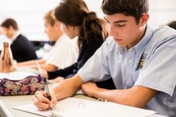 A student carefully makes notes of items in class